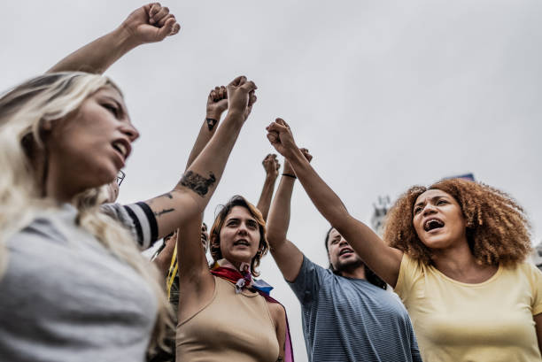 istock Protestors with fist up marching outdoors 1721103216