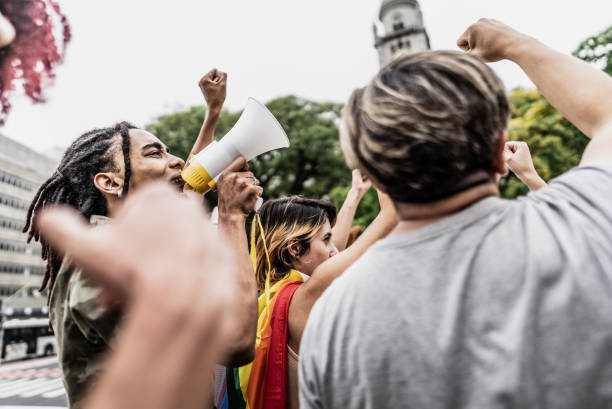 Young man talking in a megaphone during a protest in the street