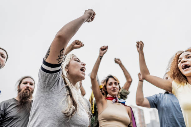 istock Protestors with fist up marching outdoors 1721103228