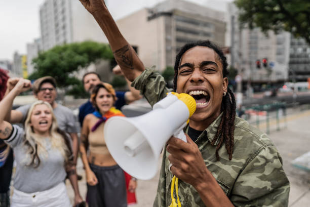 istock Young man talking in a megaphone during a protest in the street 1721103776