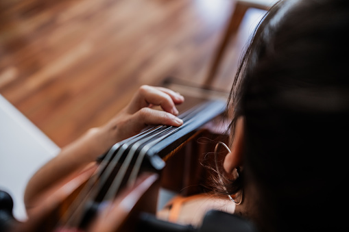 Close-up of a woman playing the cello at home