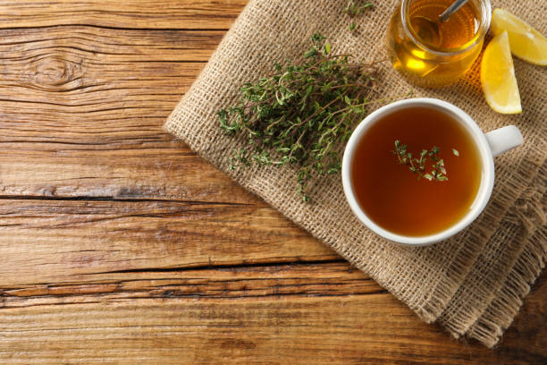 istock Aromatic herbal tea with thyme, honey and lemons on wooden table, top view. Space for text 1721117166