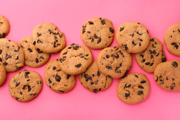 istock Many delicious chocolate chip cookies on pink background, flat lay 1721117169