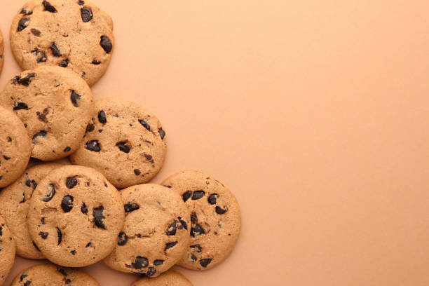 istock Many delicious chocolate chip cookies on beige background, flat lay. Space for text 1721118789