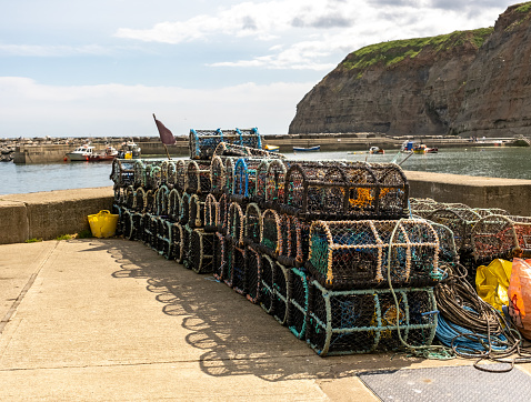 Staithes, Yorkshire, UK - June 29 2023. Crab pots lobster pots and fish traps on the quayside in the fishing village of Staithes on the North Yorkshire coast