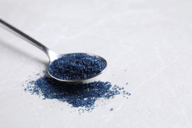 istock Spoon with blue food coloring on light grey table, closeup. Space for text 1721126093