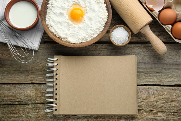 istock Blank recipe book and different ingredients on wooden table, flat lay. Space for text 1721126119