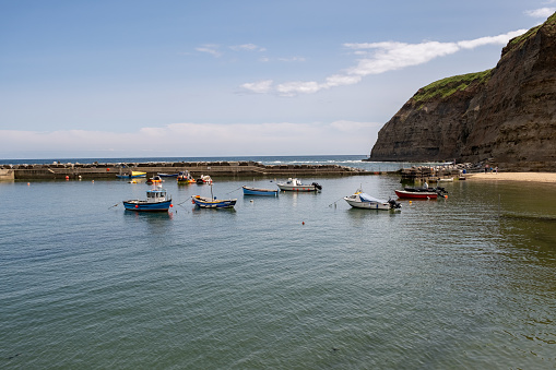 Staithes, North Yorkshire, UK - June 29 2023. \n Commercial fishing boats moored in Staithes harbour on the North Yorkshire coast