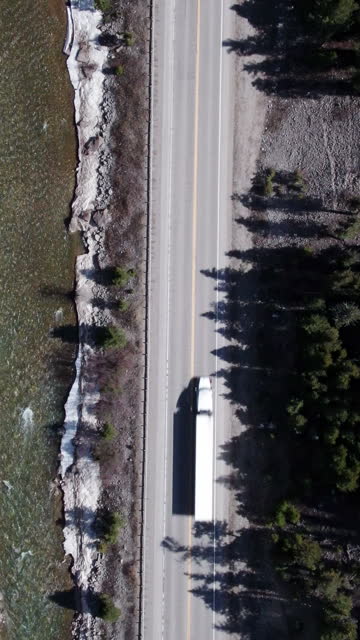 Top Down Drone Shot of a Semi Truck on a Two Lane Mountain Highway At the beginning of Spring in Wyoming