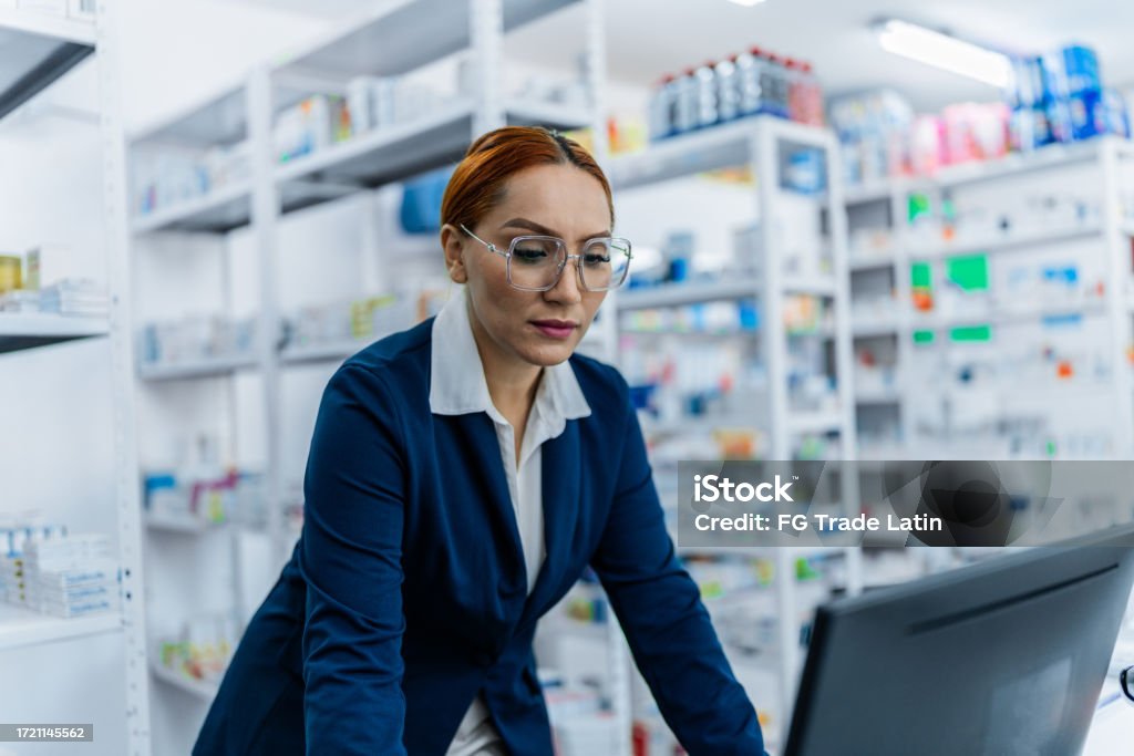 Pharmacist Using A Computer Female Pharmacist Using Computer At The Pharmacy Stock Photo - Download ...