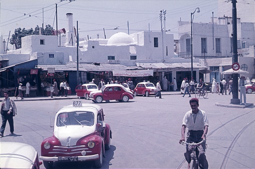 Tunis, Tunisia, 1959. Street scene with locals, taxis, shops and buildings in Tunis.