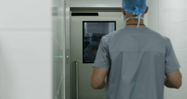 istock Surgeon comes to operating room and puts on lab coat 1721167483