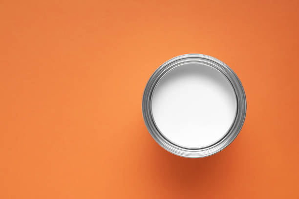 istock Can with white paint on orange background, top view. Space for text 1721174703