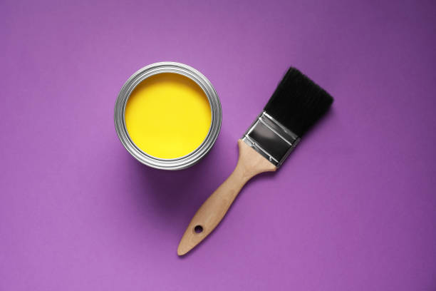 istock Can with yellow paint and brush on purple background, flat lay 1721174708