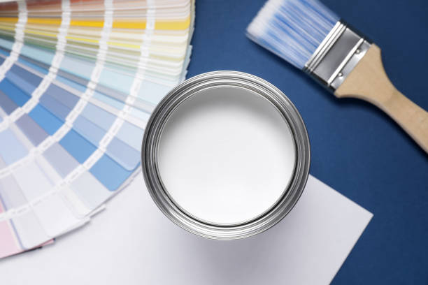 istock Can with white paint, brush and color palette on blue background, flat lay 1721174717