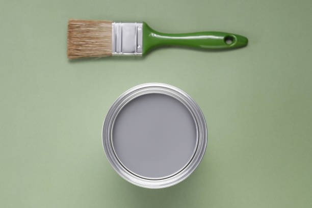 istock Can with gray paint and brush on light green background, flat lay 1721175839