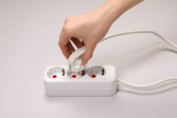 istock Woman putting plug into power strip on white background, closeup 1721188833
