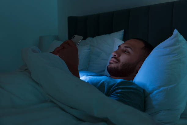 istock Young man using smartphone in bed at night. Internet addiction 1721213842