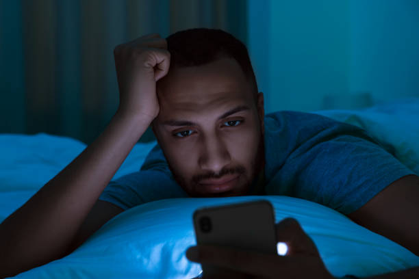 istock Young man using smartphone in bed at night. Internet addiction 1721213843