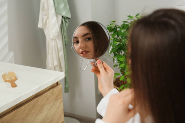 istock Beautiful woman looking in mirror in bathroom 1721213870