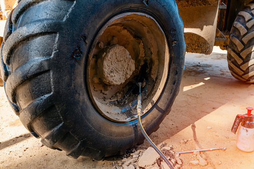 A dumper tire got a puncture and is being repaired on the building site