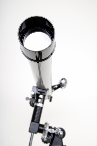 A telescope mounted on a tripod is pointed towards the camera.