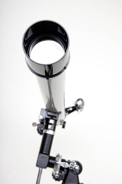 Telescope on White Background A telescope mounted on a tripod is pointed towards the camera. telescope lens stock pictures, royalty-free photos & images