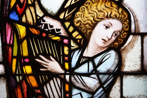 ancient stained glass angel playing a harp