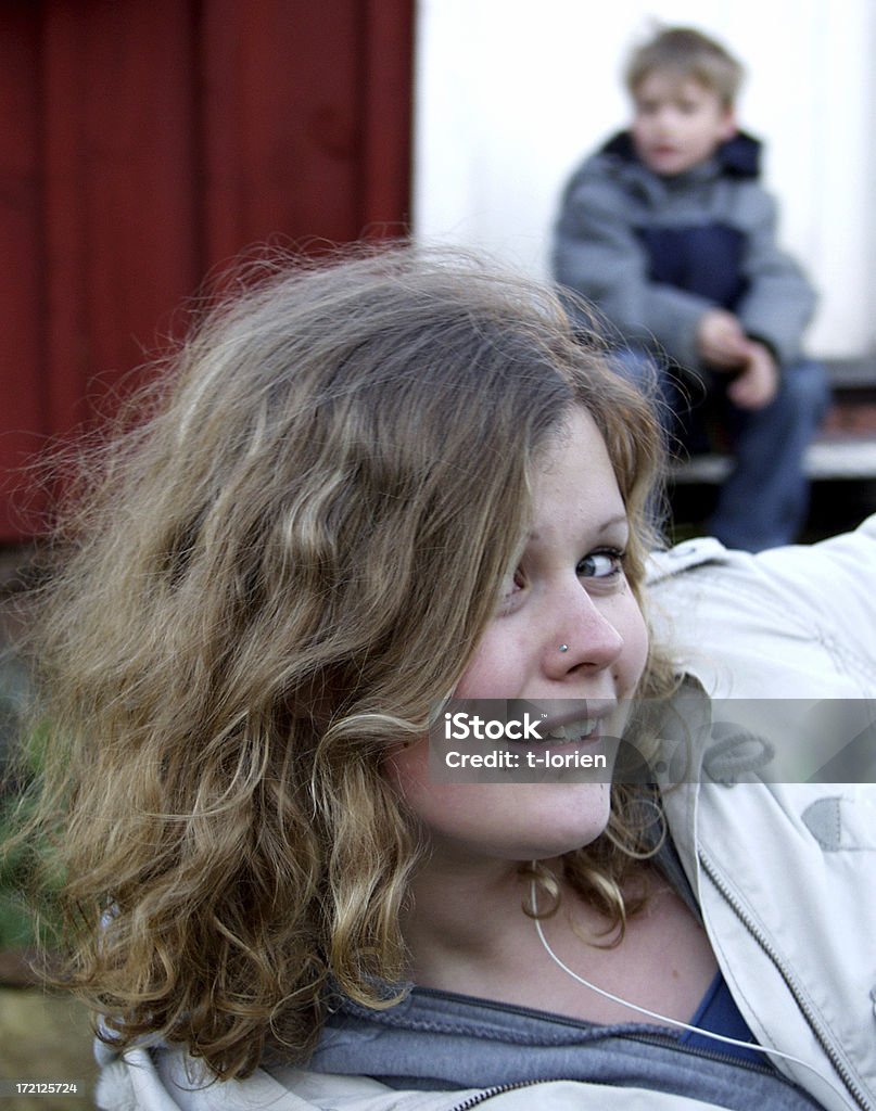 Brother & Sister. Teenage girl with her little brother sitting behind.  14-15 Years Stock Photo