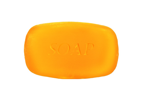 A single bar of orange soap on a white background