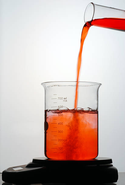 adición de líquido rojo en un vaso de precipitados - beaker laboratory weight scale physics fotografías e imágenes de stock