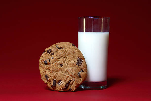 latte e biscotti su rosso - nonfat milk foto e immagini stock