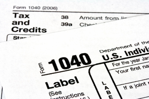 2023 IRS tax forms on a black desktop.