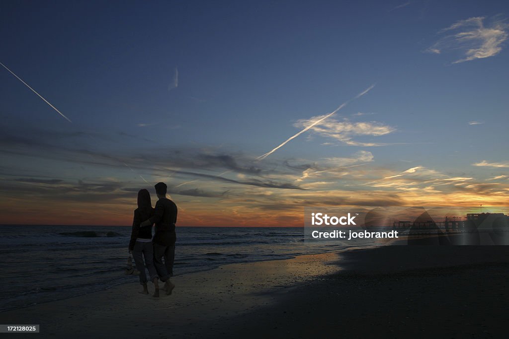 Couple sur la plage au coucher du soleil - Photo de Amour libre de droits