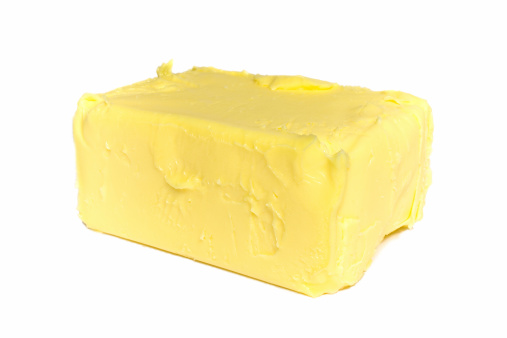 Pat of creamy butter isolated on white.