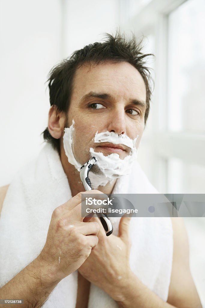 Man Shaving Portrait of a man shaving in the bathroom. http://www.lisegagne.com/images/casual.jpg Adult Stock Photo