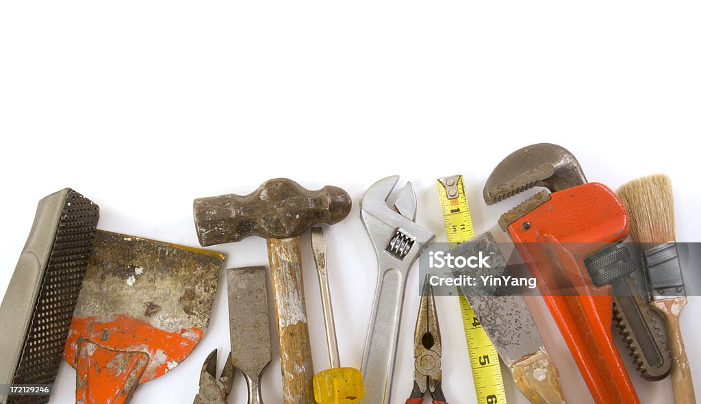 Construction Equipment, Work Tools of the Home Improvement Hardware Industry Variety of construction equipment work tools for home improvement repair and maintenance and the construction industry. The hardware store hand tools are arranged along the bottom edge of the frame with white background as a border for layout. Carpentry hammer, wrench, file, putty knife, plier, rasp, and paintbrush are featured. Adjustable Wrench Stock Photo