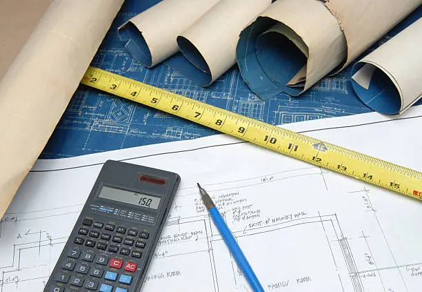 Photo of Calculator with blueprints for estimates of renovation costs