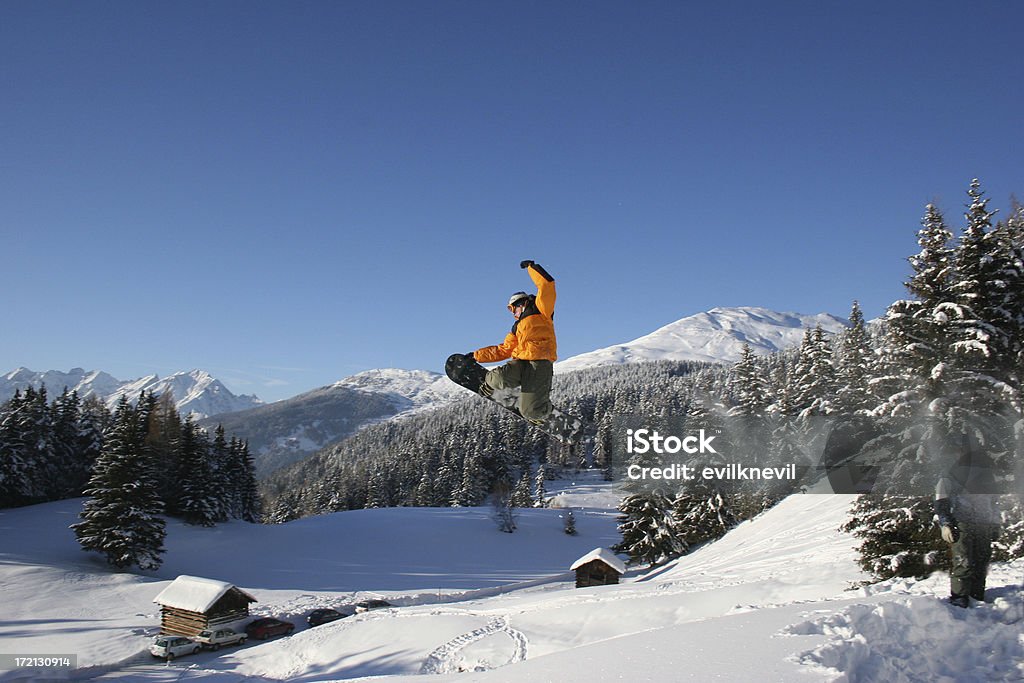 snowboarder backsideair snowboarder doing a backsideair in a beautiful mountain arena Activity Stock Photo
