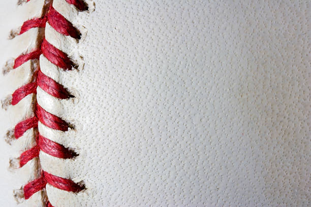 Baseball Background A baseball with the seams on the left. baseball threads stock pictures, royalty-free photos & images