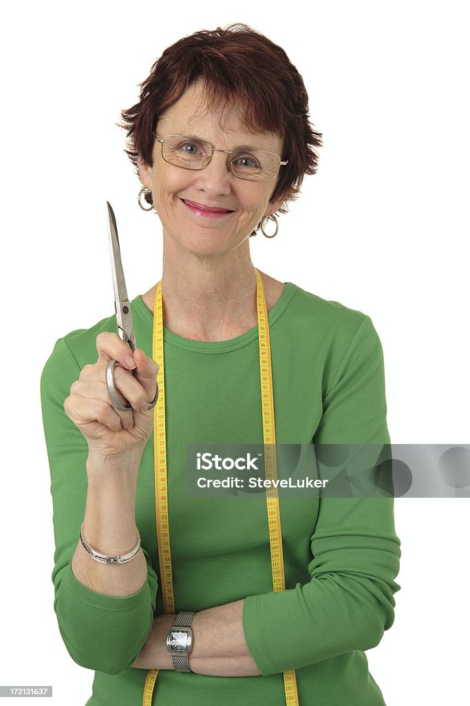 Tailor Smiling woman with a tape measure around her neck and holding scissors. Fashion Stock Photo