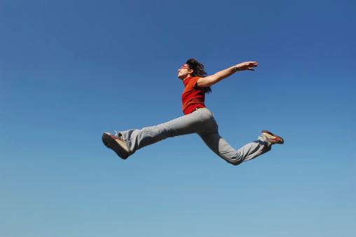 young woman is jumping in the sky.