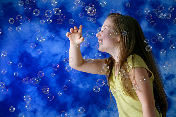 istock Girl playing with soap bubbles 172132054