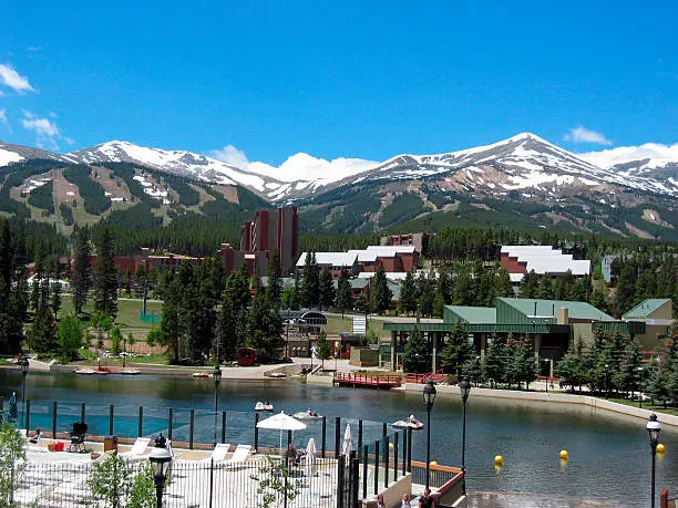 Photo of Lush summer resort facing snowy mountains in the distance