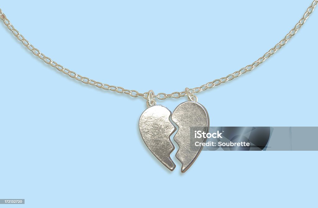 Best Friends Forever! A silver broken heart pendant on a blue background Friendship Stock Photo