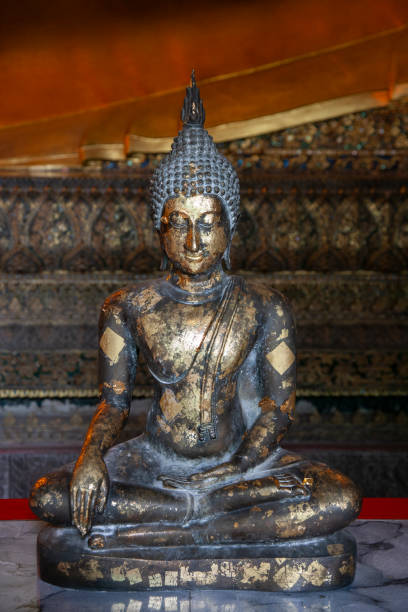 A Buddha statue covered in pieces of gold leaf signifying an offering to Buddha, Bangkok, Thailand