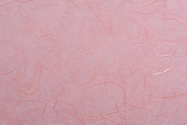 Overhead shot of red silk threads in a row on white background.