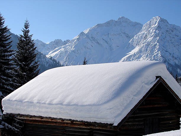 wintertide a ski lodge in the austrian alps....moutains and blue sky in the background kleinwalsertal stock pictures, royalty-free photos & images