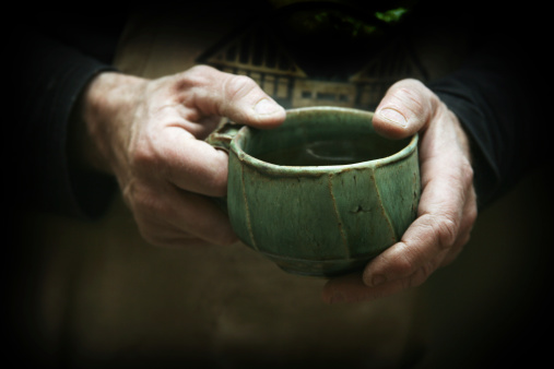 potter's hands hold handmade pottery mug