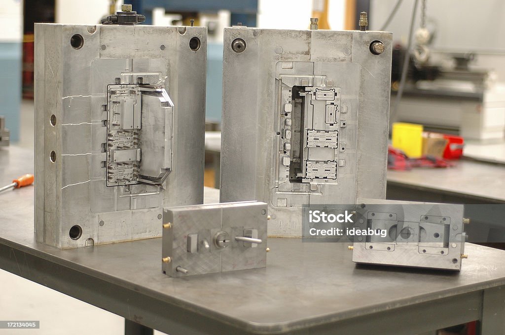 Metal Molding Units Two sets of metal molding units used for molding plastics.  Focus is on back two units.  Slightly grainy because it was shot in a factory under florescent lighting. Molding a Shape Stock Photo